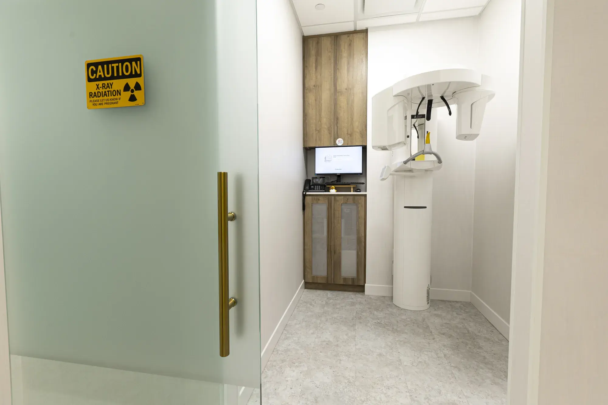 Clinical room viewed through a frosted-glass doorway