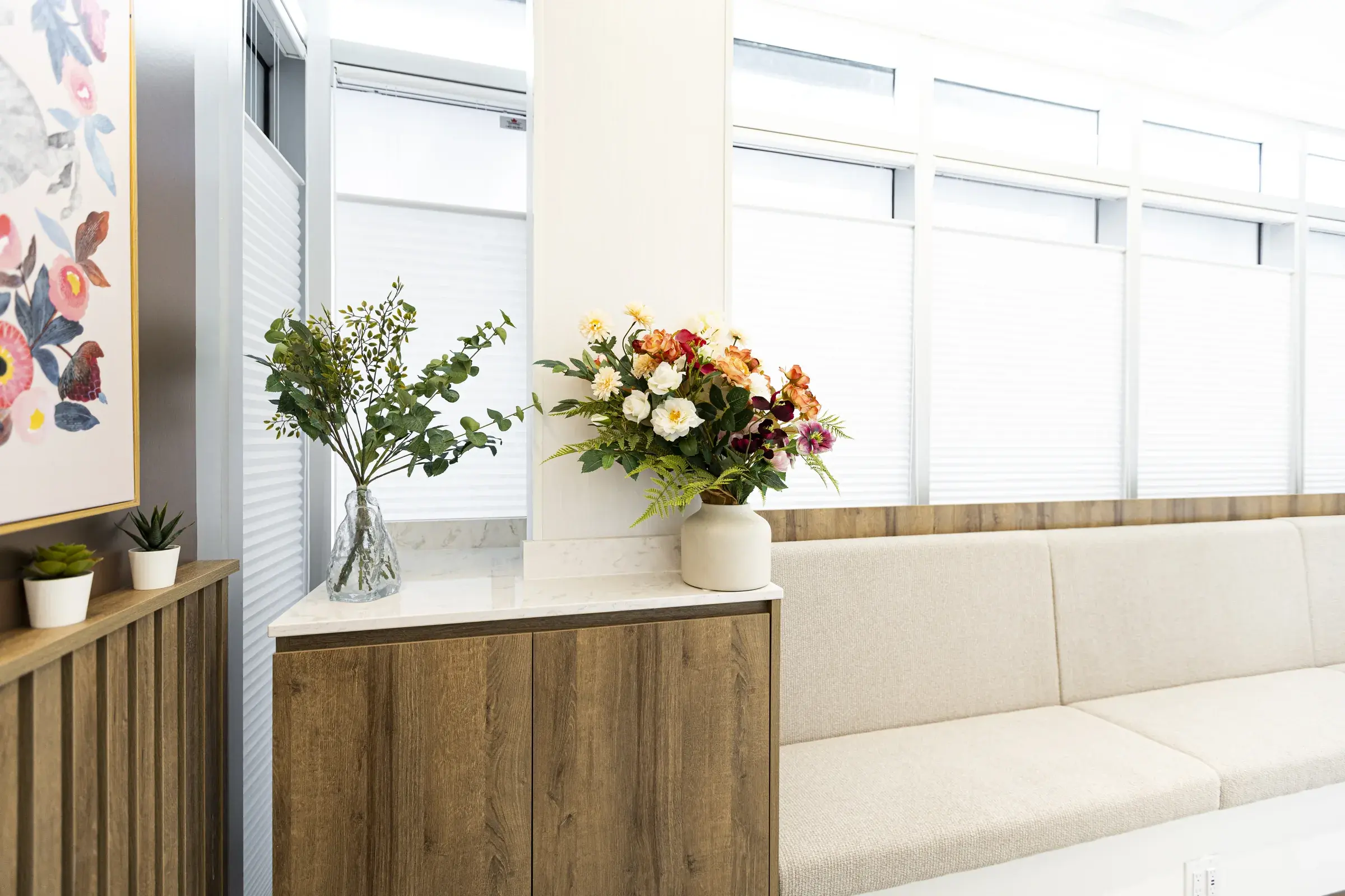 Flowers, artwork, and seating in the Heather Street Dental waiting area